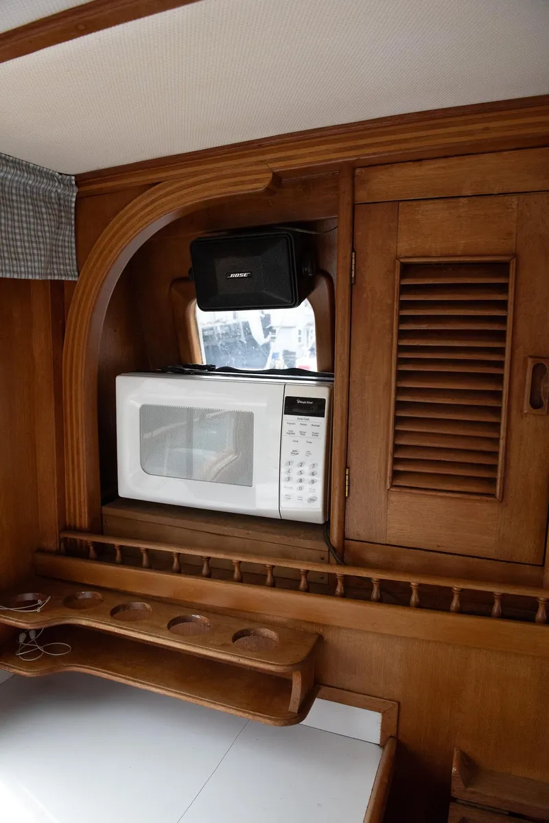 Slide: The Image of 1978 CHB Puget Trawler 37 interior with microwave and wooden cabinetry. - 24