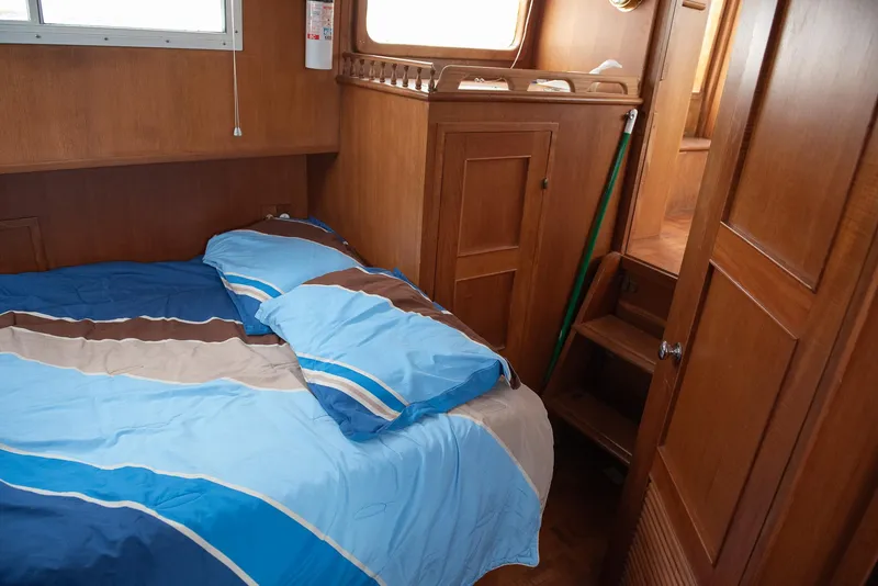 Slide: The Image of Cozy cabin interior of 1978 CHB Puget Trawler 37 with blue bedding. - 35