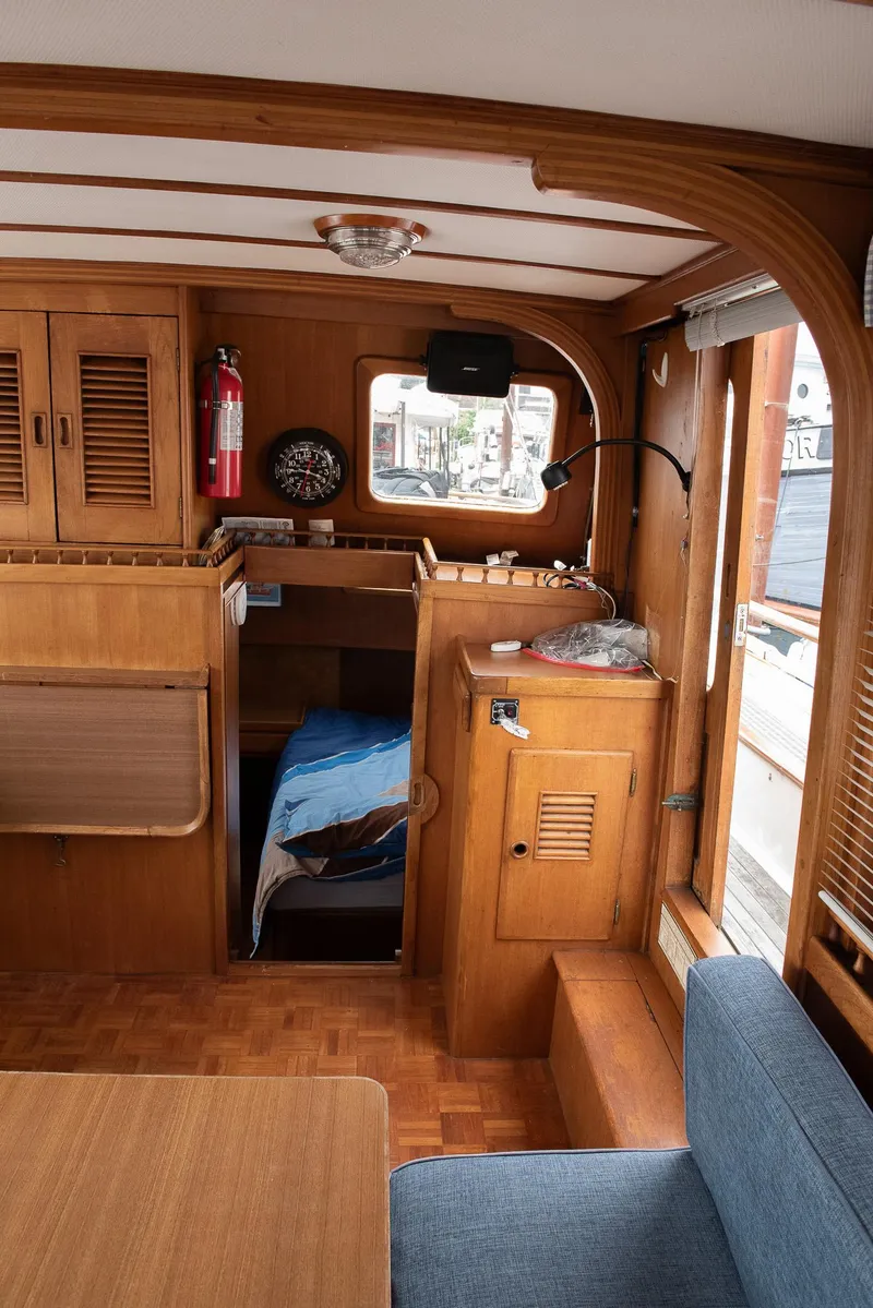 Slide: The Image of 1978 CHB Puget Trawler 37 interior with wooden cabinetry and cozy sleeping area. - 4