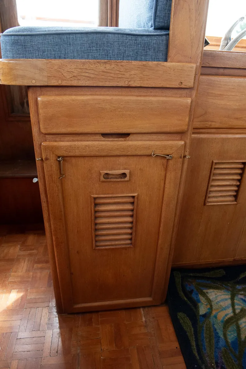 Slide: The Image of Wooden interior of a 1978 CHB Puget Trawler 37, featuring a cabinet with louvered door. - 5