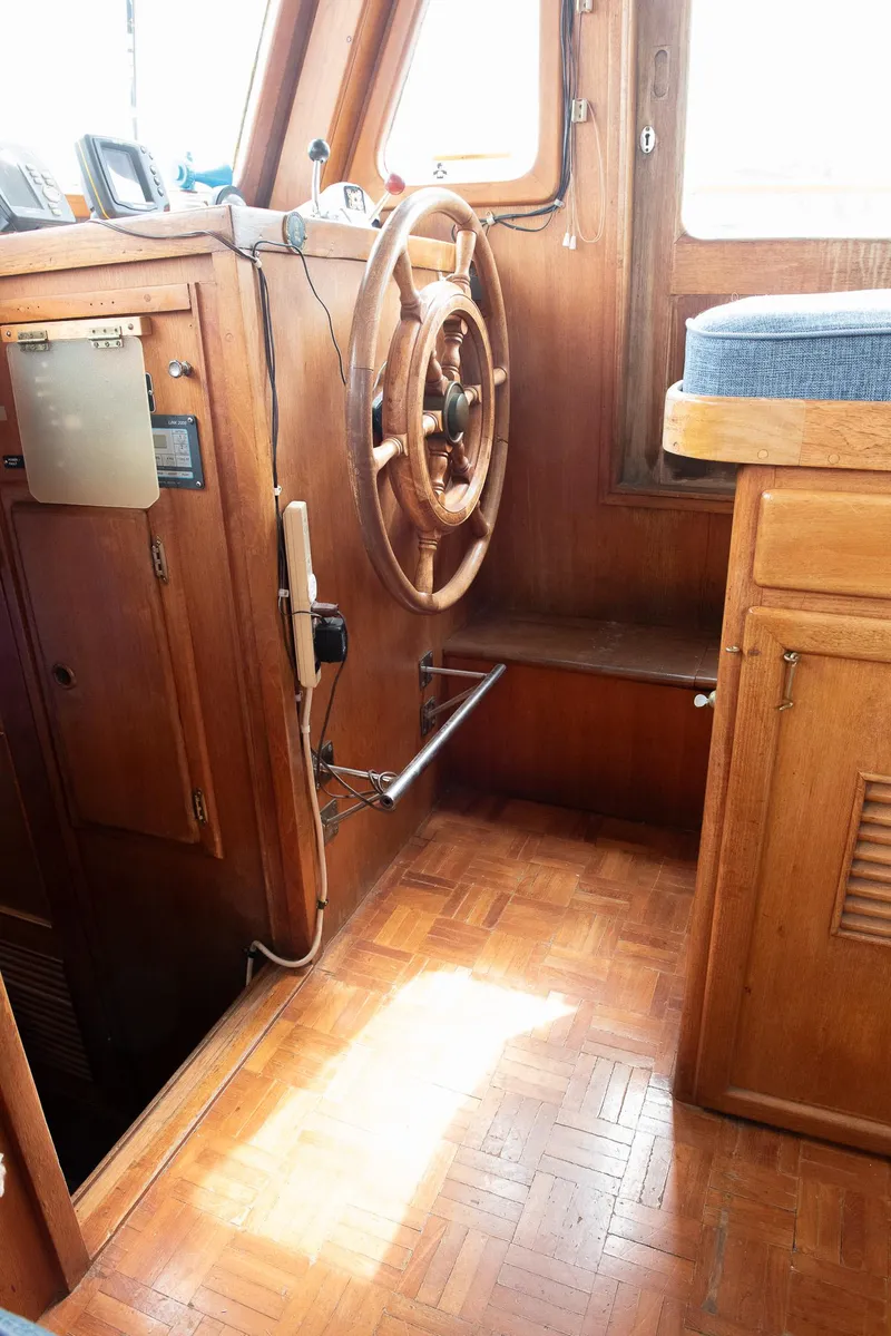 Slide: The Image of 1978 CHB Puget Trawler 37 interior with wooden helm and parquet flooring. - 7