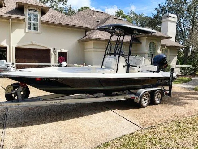 Slide: The Image of 2019 ShearWater 23LTZ boat on a trailer in front of a house. - 10