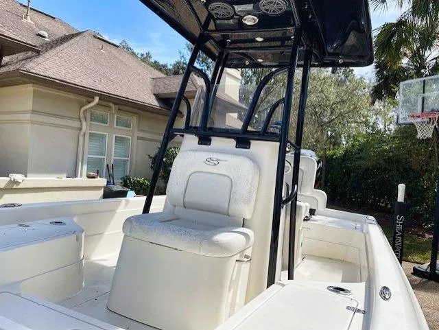 Slide: The Image of 2019 ShearWater 23LTZ boat with center console and seating, parked near a house. - 12