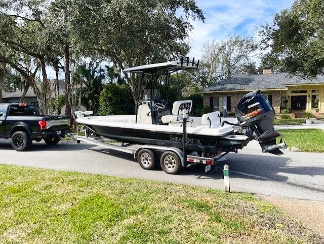 Slide: The Image of 2019 ShearWater 23LTZ boat on trailer, hitched to a black truck. - 18