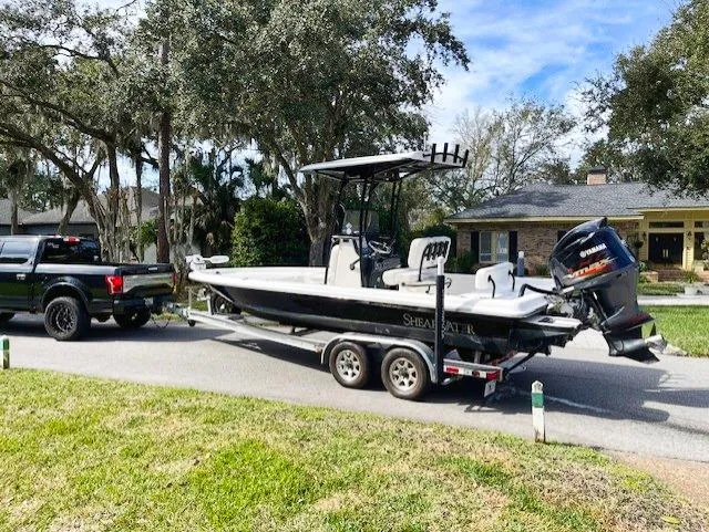 Slide: The Image of 2019 ShearWater 23LTZ boat on trailer hitched to black truck. - 19