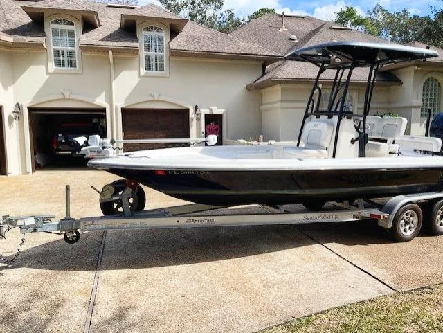 Slide: The Image of 2019 ShearWater 23LTZ boat on trailer in front of a house. - 9