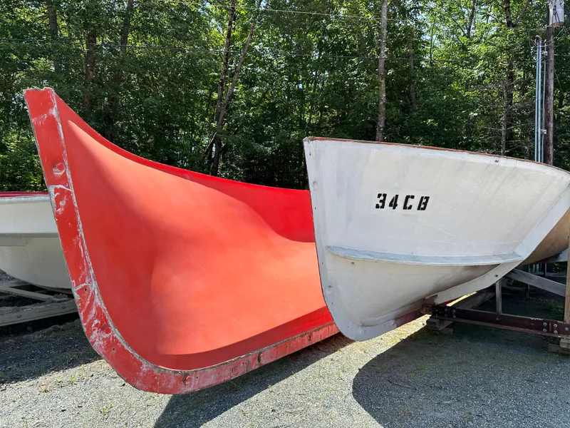 Slide: The Image of 2024 Beal Calvin Beal MOLDS boat hulls, red and white, in outdoor setting. - 18