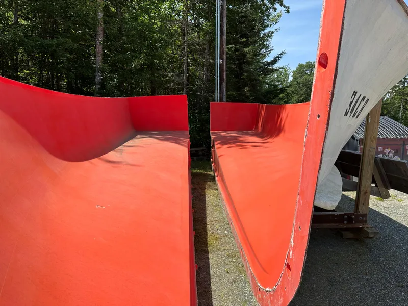 Slide: The Image of 2024 Beal Calvin Beal MOLDS boat hulls in vibrant red, outdoors in a wooded area. - 19