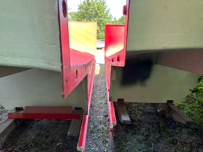 Slide: The Image of 2024 Beal Calvin Beal MOLDS boat hulls on wooden supports outdoors. - 24