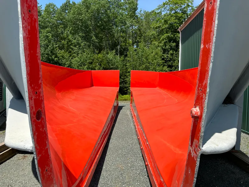 Slide: The Image of Red boat molds by Beal, Calvin Beal MOLDS 2024, outdoors with trees in background. - 7