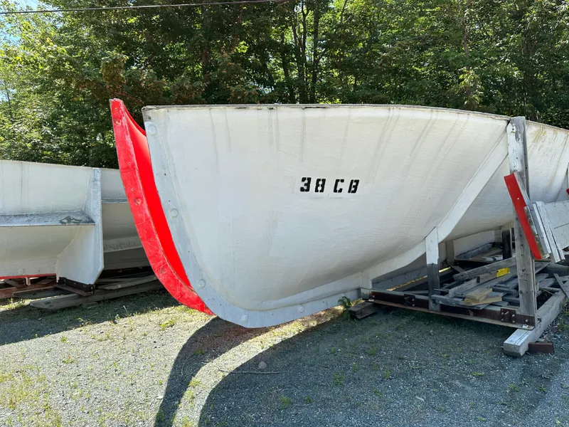 Slide: The Image of 2024 Beal Calvin Beal MOLDS boat hull with red accents, displayed outdoors. - 9