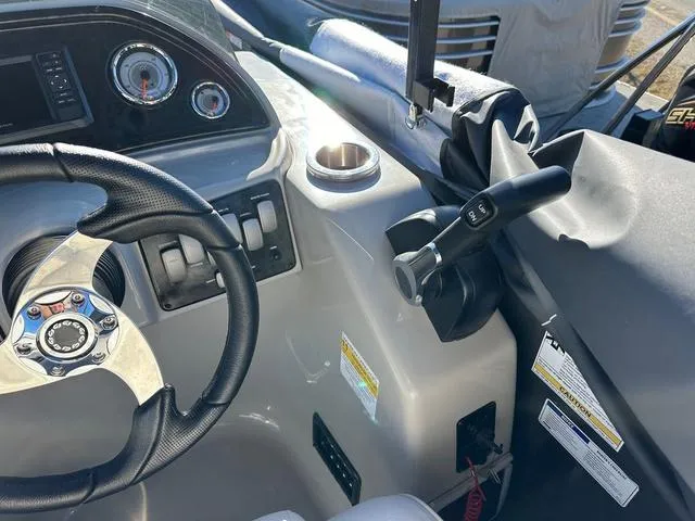 Slide: The Image of 2024 SunCatcher Fusion 322FC boat dashboard with steering wheel and controls. - 10
