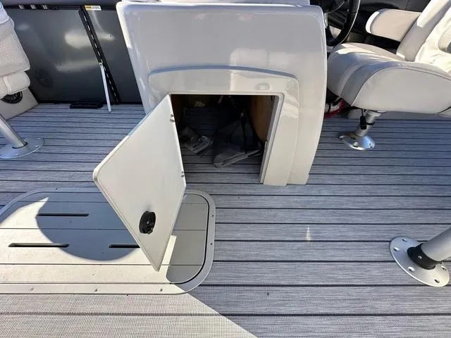 Slide: The Image of 2024 SunCatcher Fusion 322FC boat interior with open storage compartments. - 12