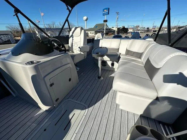Slide: The Image of 2024 SunCatcher Fusion 322FC boat interior with plush seating and modern helm. - 13