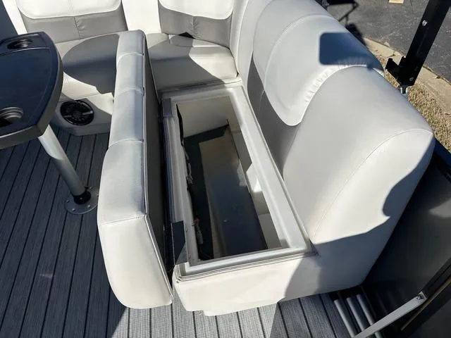 Slide: The Image of 2024 SunCatcher Fusion 322FC boat interior with open storage compartment. - 14