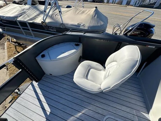 Slide: The Image of 2024 SunCatcher Fusion 322FC boat interior with white seating and storage compartment. - 15