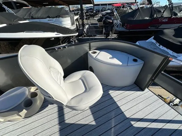 Slide: The Image of 2024 SunCatcher Fusion 322FC boat interior with white seating and storage compartment. - 17