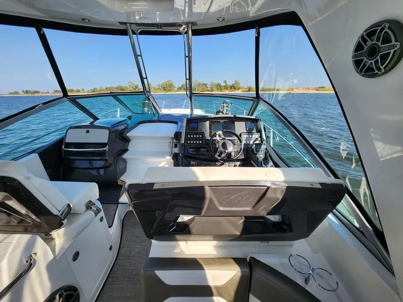 Slide: The Image of 2019 Monterey 335SY yacht interior with steering wheel, dashboard, and seating on open water. - 11