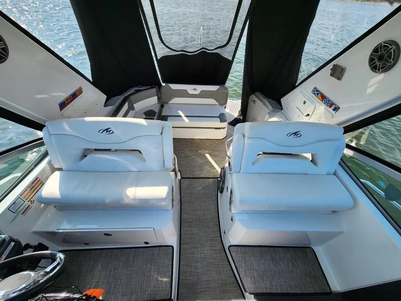 Slide: The Image of 2019 Monterey 335SY boat interior with white seating and lake view. - 19