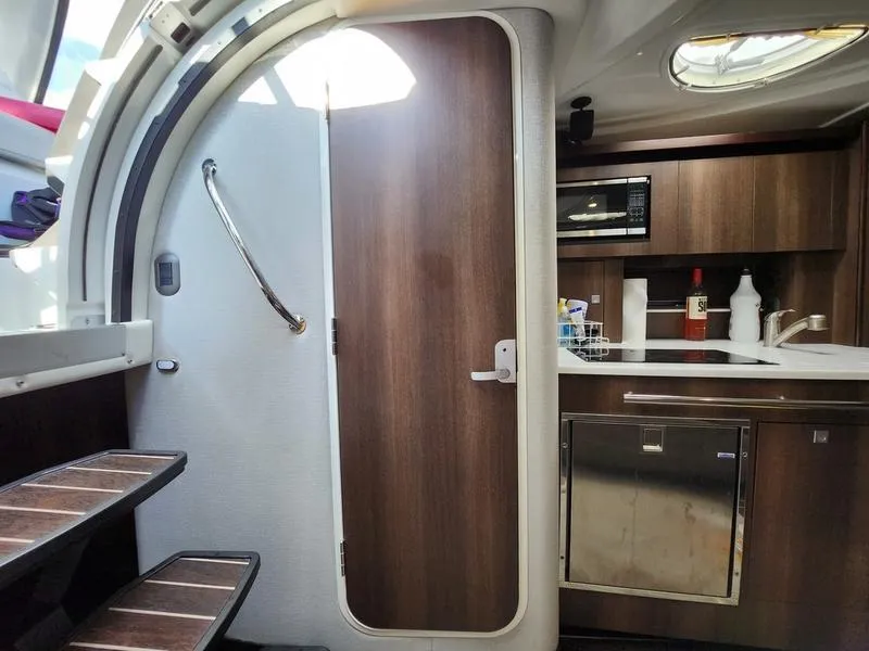 Slide: The Image of 2019 Monterey 335SY yacht interior with kitchenette, wooden cabinetry, and stairs. - 22