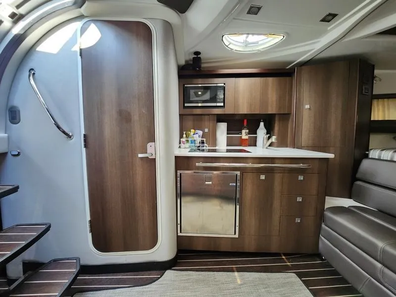 Slide: The Image of 2019 Monterey 335SY yacht interior with modern kitchenette and seating area. - 25