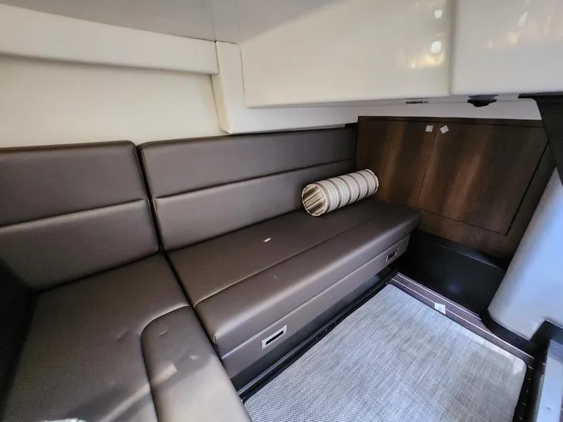 Slide: The Image of 2019 Monterey 335SY cabin interior with brown leather seating and striped pillow. - 32