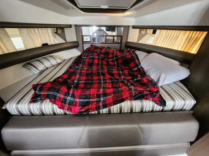 Slide: The Image of Cozy cabin bed in 2019 Monterey 335SY yacht with plaid blanket and striped pillows. - 43