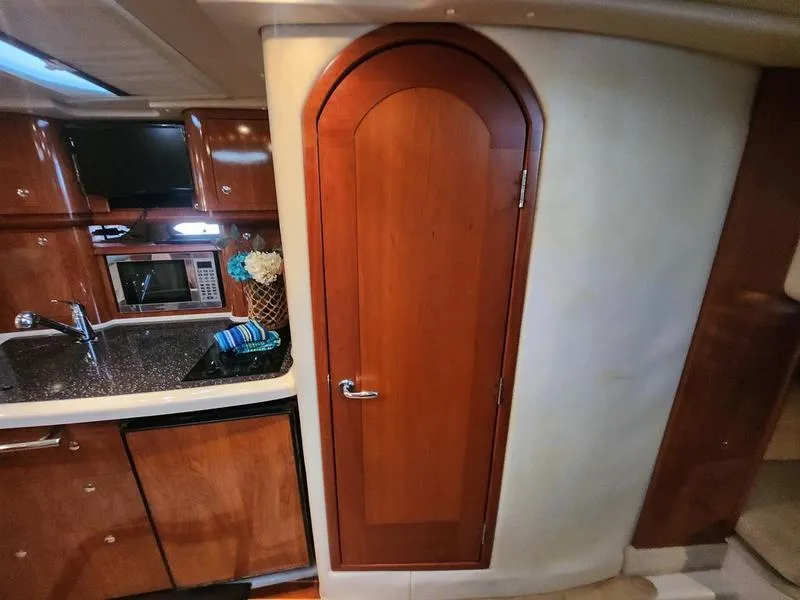 Slide: The Image of 2007 Four Winns 358 Vista yacht interior with wooden cabinetry and arched door. - 23