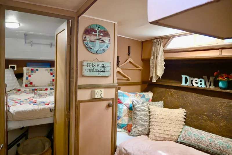Slide: The Image of 1979 Uniflite Double Cabin interior with cozy bedding, decorative pillows, and nautical-themed decor. - 12