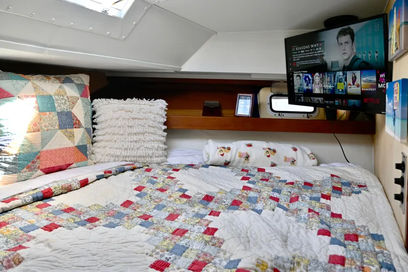 Slide: The Image of 1979 Uniflite Double Cabin interior with cozy bedding, TV, and decorative pillows. - 16