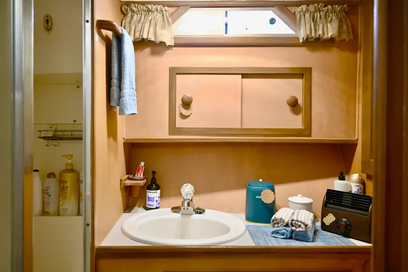 Slide: The Image of 1979 Uniflite Double Cabin bathroom with sink, toiletries, and wooden cabinetry. - 18