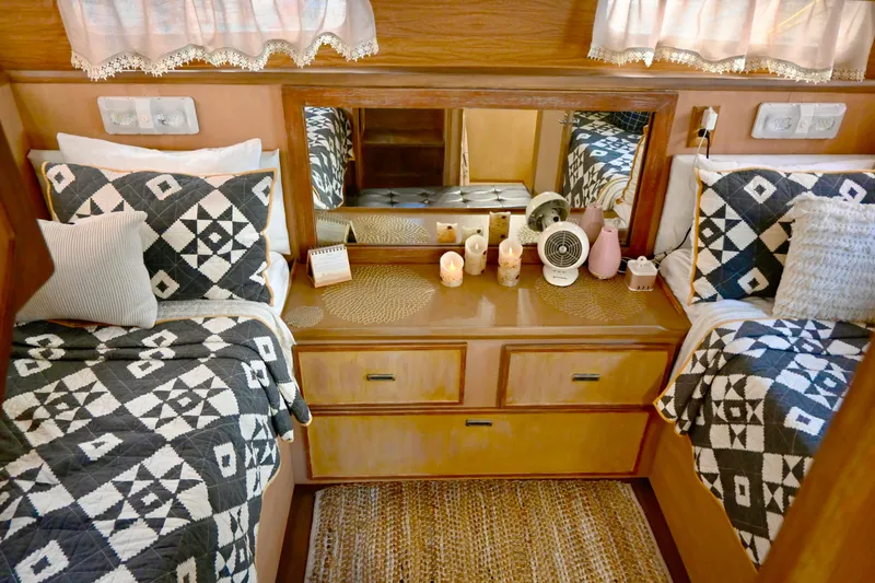 Slide: The Image of 1979 Uniflite Double Cabin interior with twin beds, geometric bedding, and wooden cabinetry. - 21