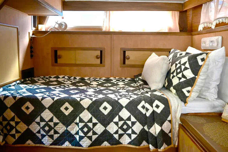 Slide: The Image of 1979 Uniflite Double Cabin interior with geometric-patterned bedding and wooden accents. - 22