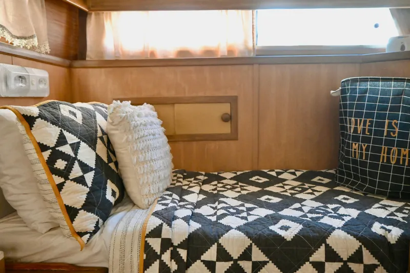Slide: The Image of Cozy 1979 Uniflite Double Cabin interior with geometric bedding and decorative pillows. - 23