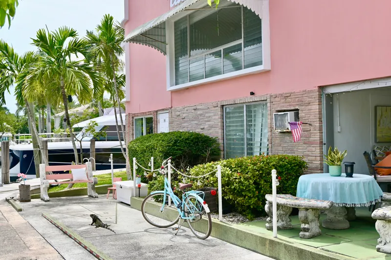 Slide: The Image of Pink building with patio, bicycle, and tropical plants near a 1979 Uniflite Double Cabin boat. - 27