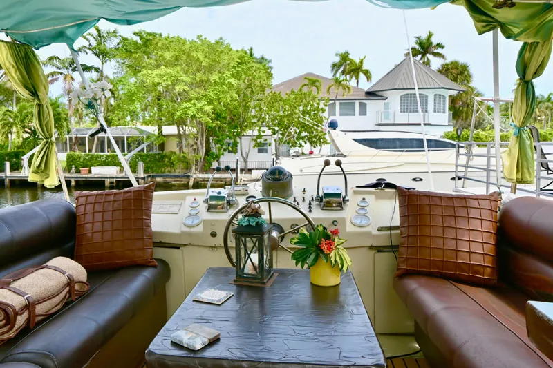 Slide: The Image of 1979 Uniflite Double Cabin interior with cozy seating, decorative pillows, and waterfront view. - 3