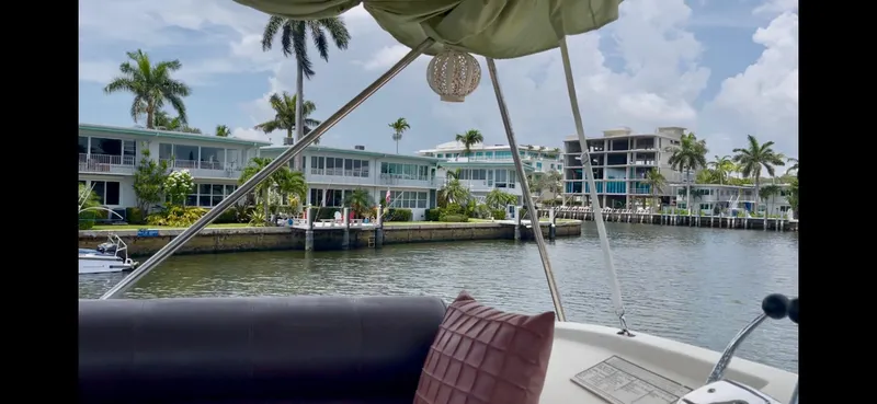Slide: The Image of 1979 Uniflite Double Cabin boat on a scenic waterfront with palm trees and modern buildings. - 31