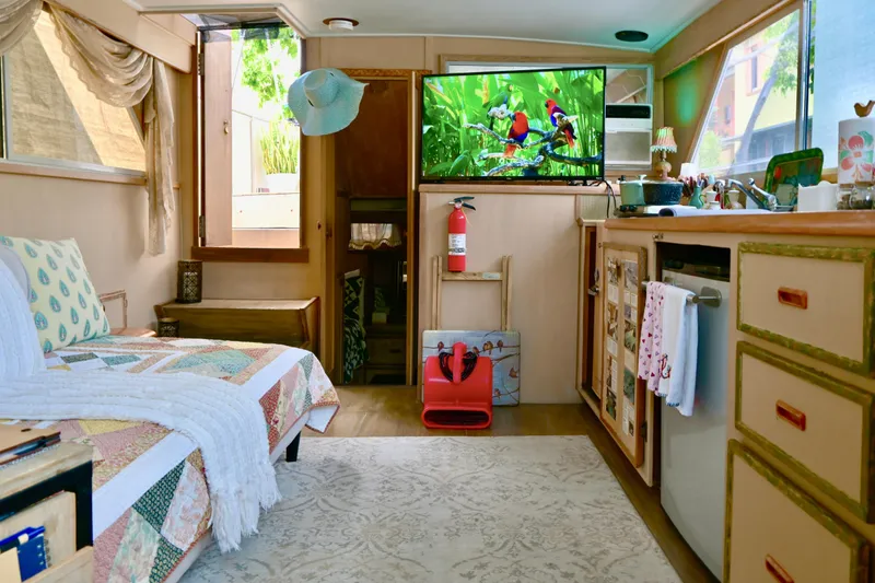 Slide: The Image of 1979 Uniflite Double Cabin interior with cozy bed, TV, kitchenette, and decor. - 4