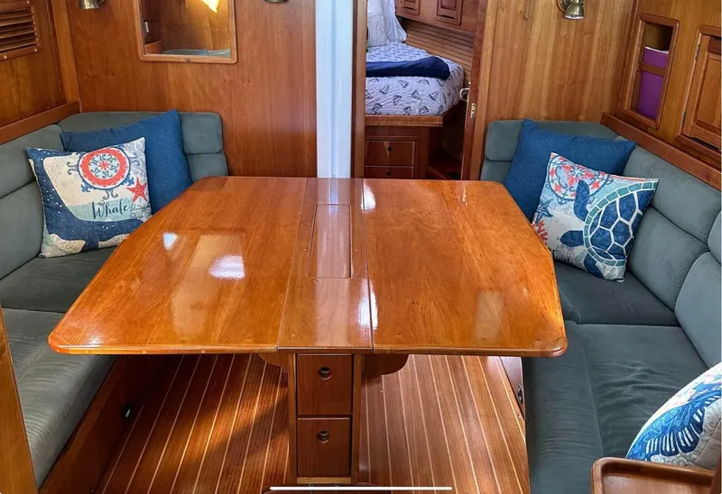 Slide: The Image of Saga 43 (2001) yacht interior with wooden dining table and cushioned seating. - 6