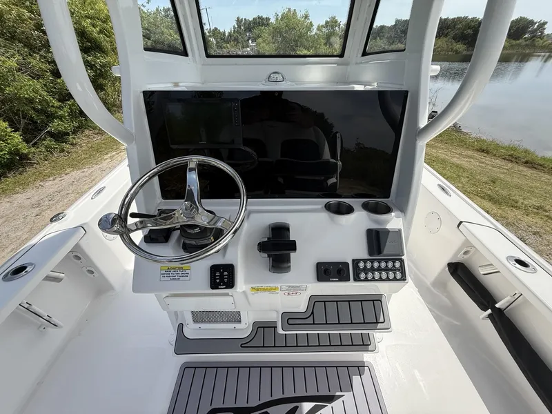 Slide: The Image of 2024 Tidewater 2410 Bay Max boat console with steering wheel and controls. - 10