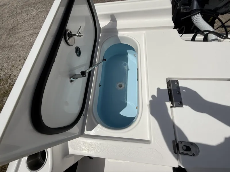 Slide: The Image of 2024 Tidewater 2410 Bay Max boat livewell, open lid, white and blue interior. - 18