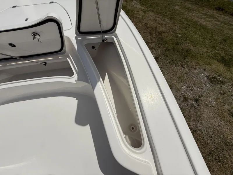 Slide: The Image of 2024 Tidewater 2410 Bay Max boat storage compartment open, showcasing interior space. - 27