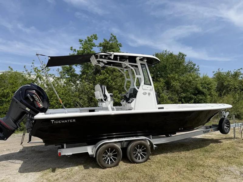 Slide: The Image of 2024 Tidewater 2410 Bay Max boat on trailer, black hull, Yamaha engine, outdoors. - 29