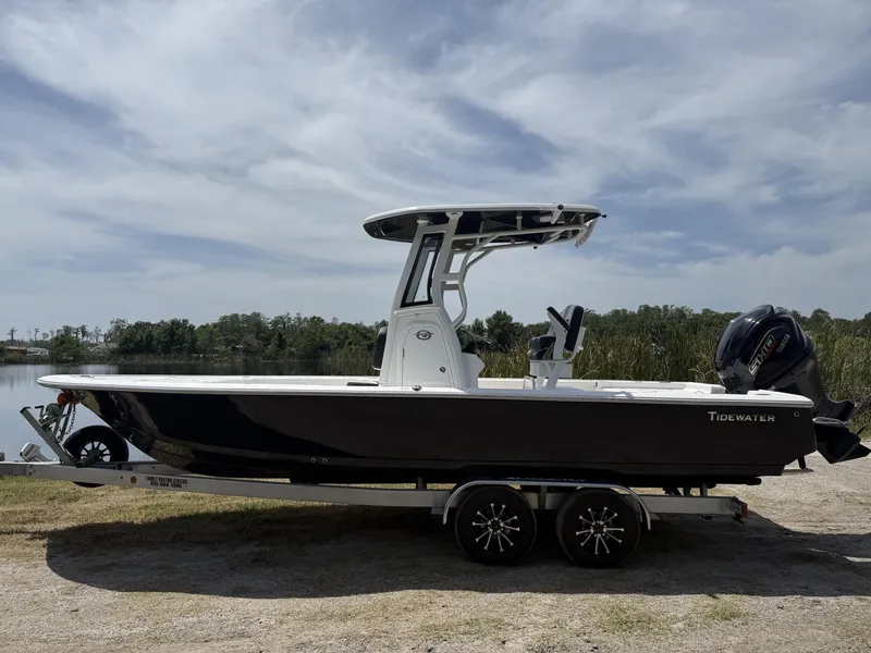 Slide: The Image of 2024 Tidewater 2410 Bay Max boat on trailer by a lake under cloudy sky. - 33