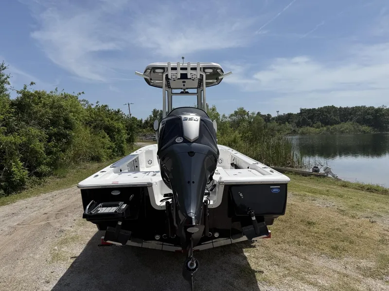 Slide: The Image of 2024 Tidewater 2410 Bay Max boat with outboard motor near a serene lake. - 4