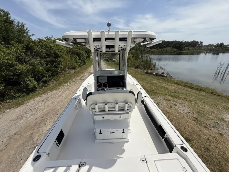 Slide: The Image of 2024 Tidewater 2410 Bay Max boat on a lakeside dirt path. - 8