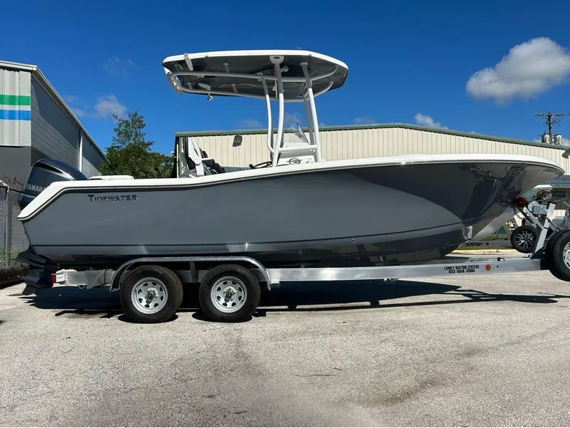 Slide: The Image of 2024 Tidewater 220 LXF boat on a trailer, parked outdoors under a clear blue sky. - 17