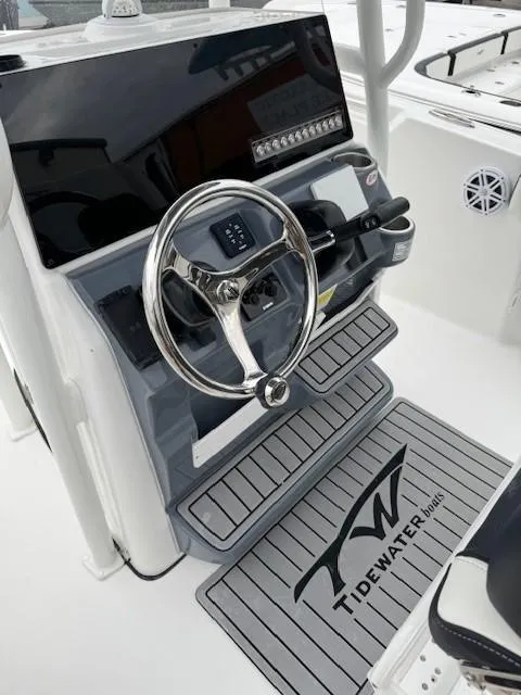 Slide: The Image of 2024 Tidewater 220 LXF boat helm with steering wheel and control panel. - 20