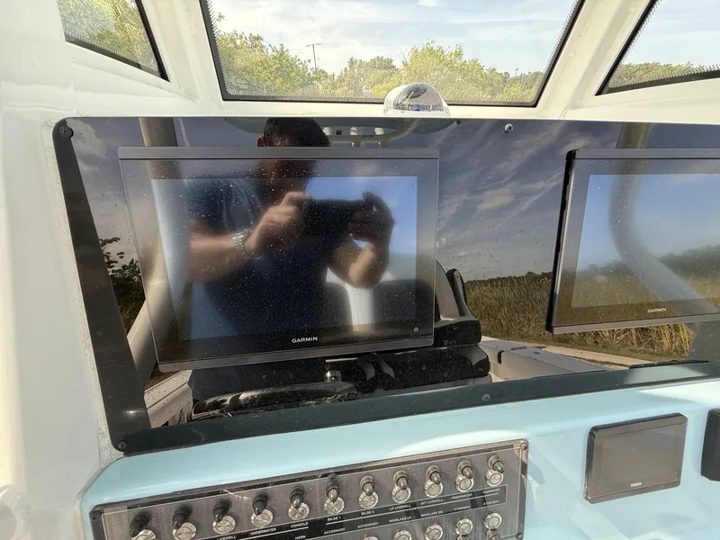 Slide: The Image of 2024 Tidewater 256 CC Adventure dashboard with Garmin displays and control panel. - 12