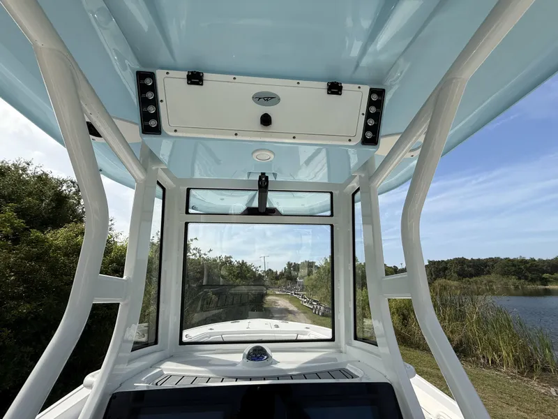 Slide: The Image of 2024 Tidewater 256 CC Adventure boat interior with blue ceiling and clear windows. - 17